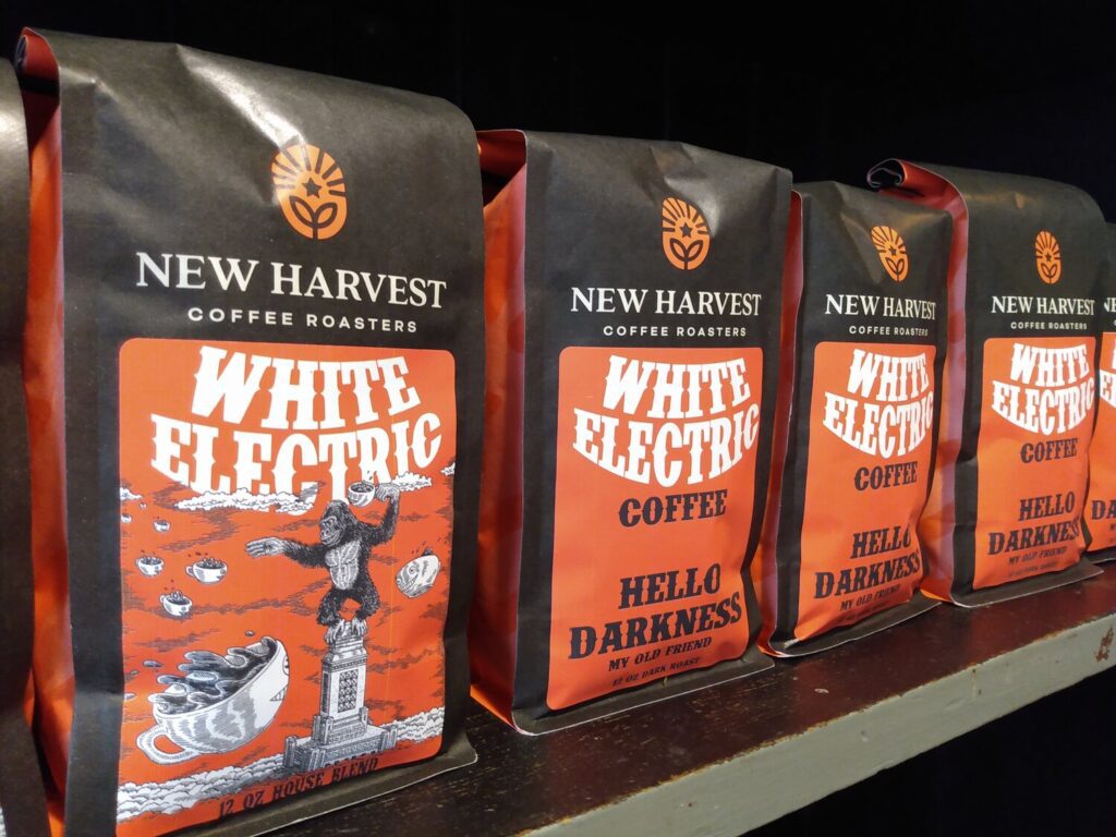 A row of one pound bags of coffee beans on a shelf